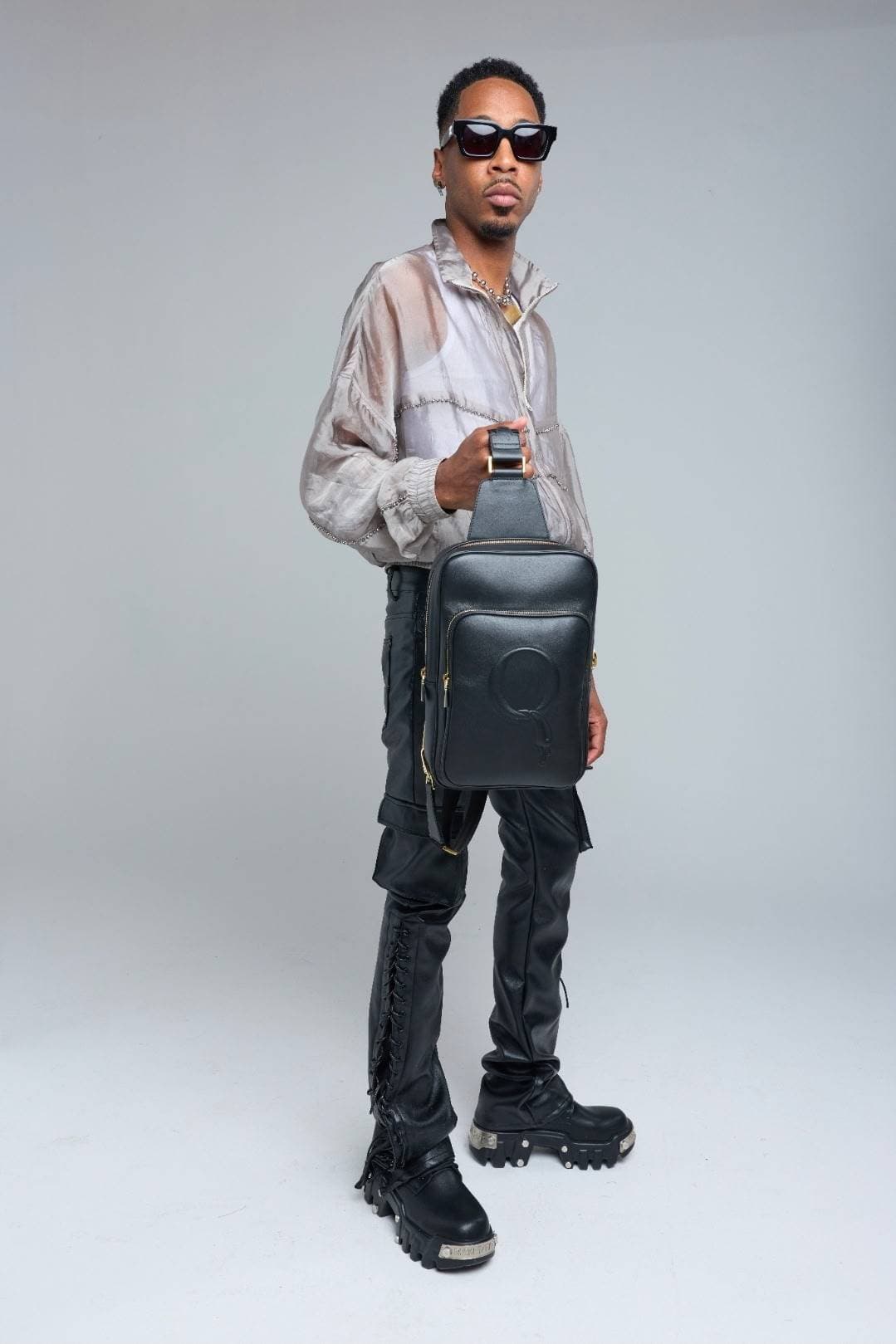 Full look — Statement Sling held with sheer jacket and lace-up pants