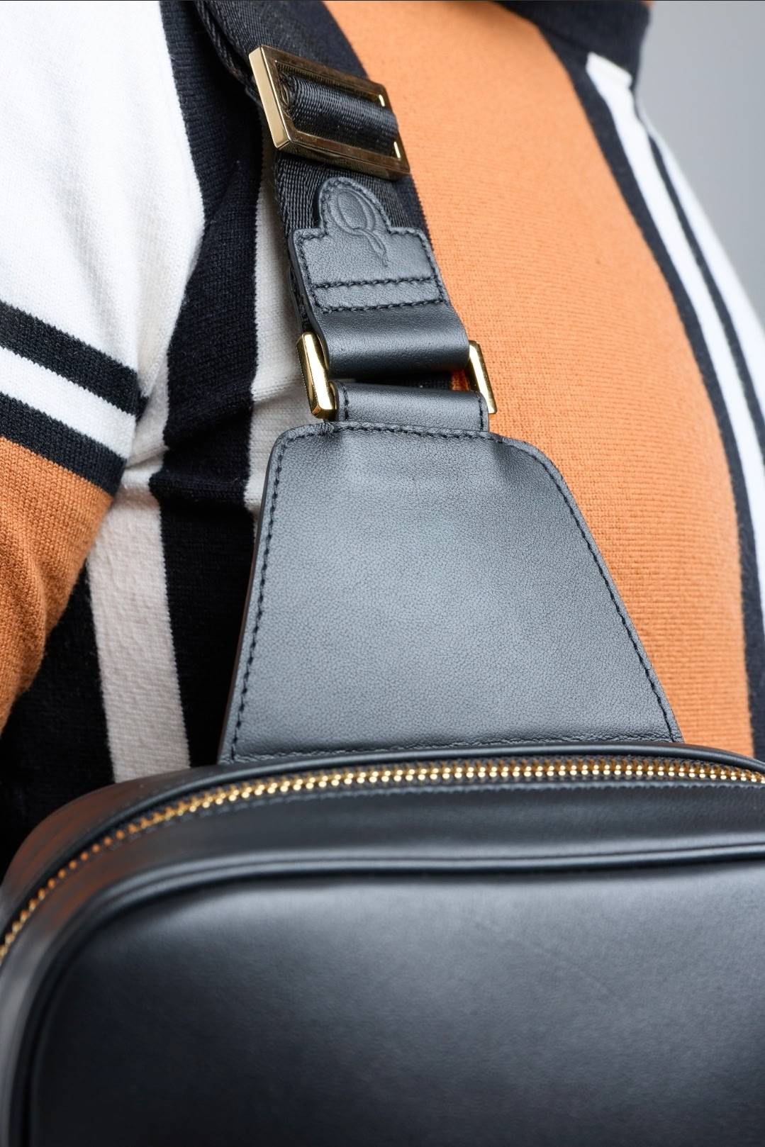 Strap hardware and embossed Q leather tab detail